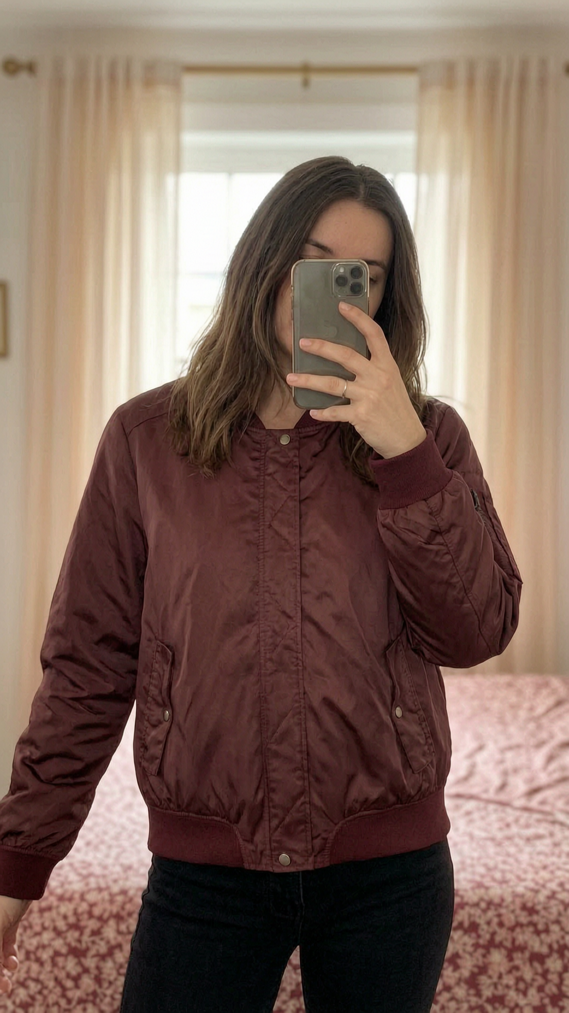 🩶 Petit manteau bordeaux debout, face à la caméra, dans une chambre à la lumière douce, avec une lumière naturelle filtrant par la fenêtre.