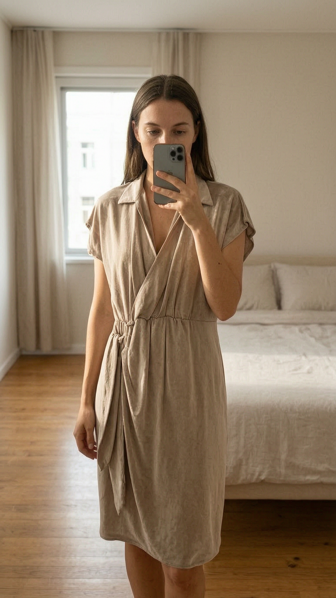 Magnifique robe beige Tamaris M - Abito estivo donna beige m in piedi, rivolto verso la fotocamera, in una camera da letto con luce soffusa e luce naturale che filtra dalla finestra.