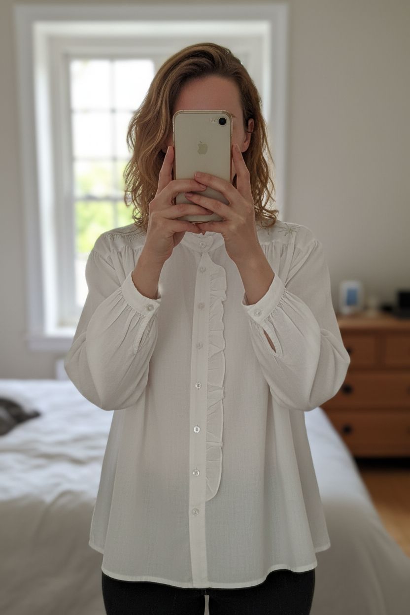 Jolie chemise broderies fil d'or debout, face à la caméra, dans une chambre à la lumière douce, avec une lumière naturelle filtrant par la fenêtre.