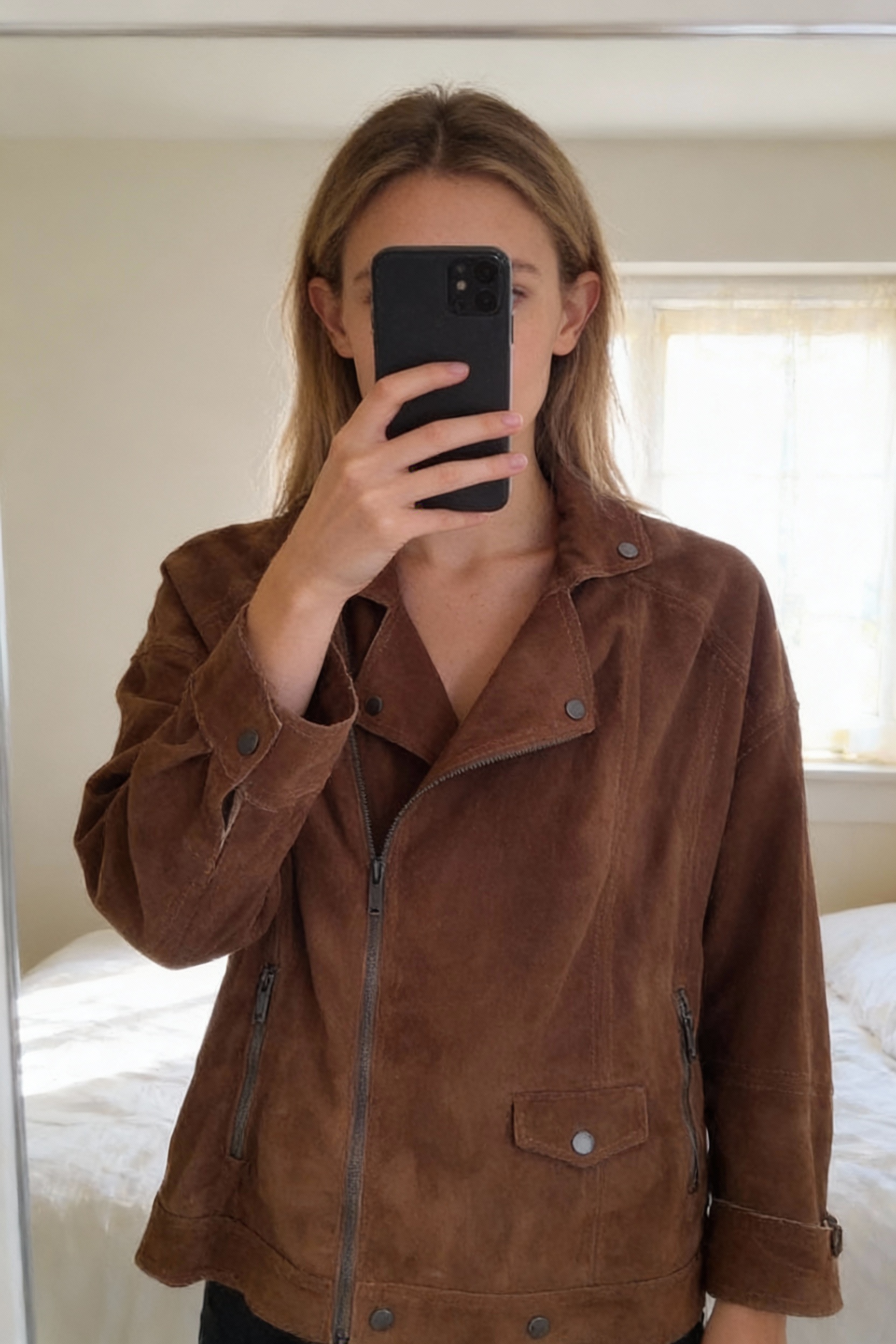 Veste Pepe Jean taille M debout, face à la caméra, dans une chambre à la lumière douce, avec une lumière naturelle filtrant par la fenêtre.