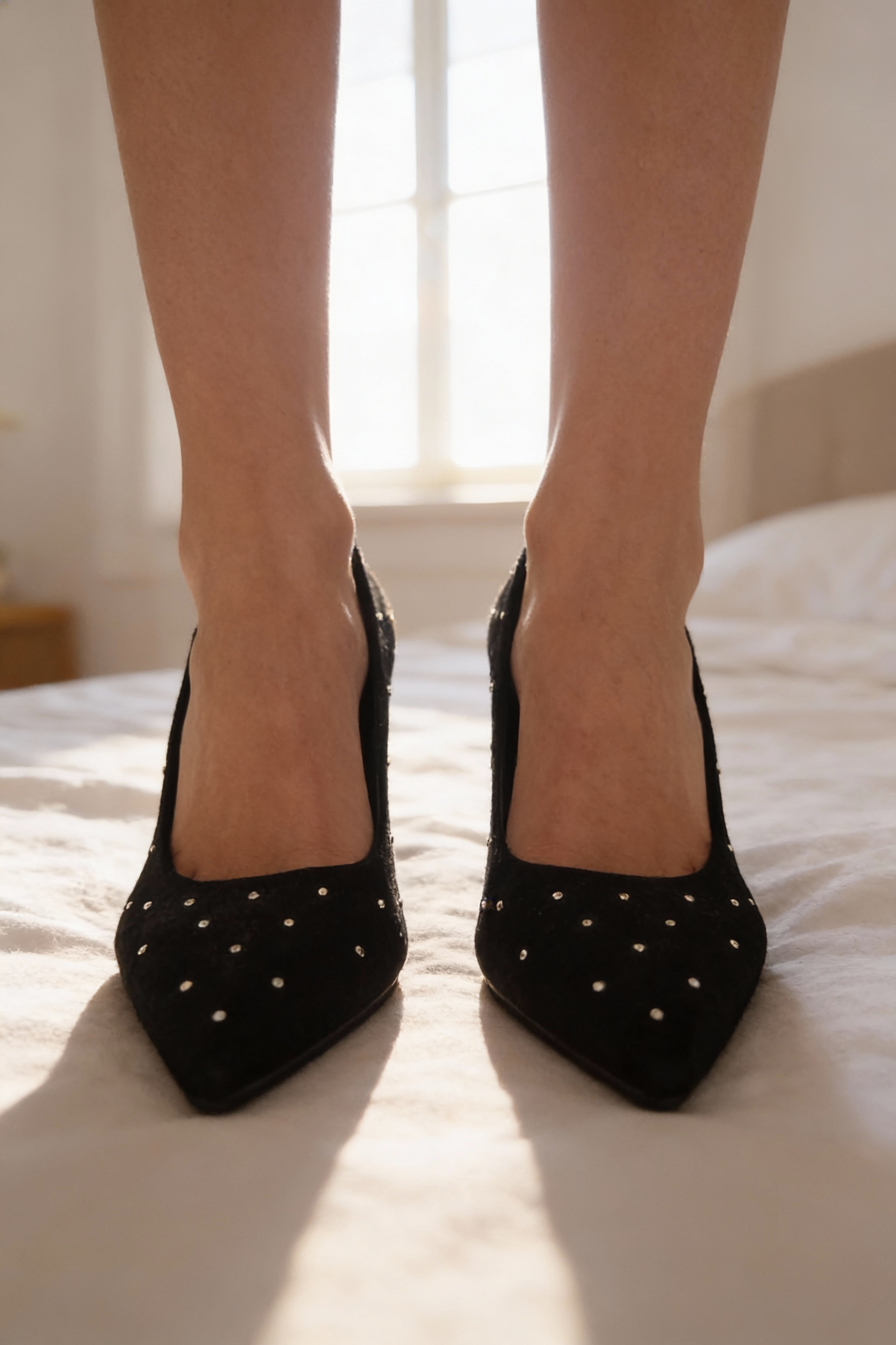 Comme neuf escarpins noir avec fausses perles aspect suedé/daim-Bocage-37 debout, face à la caméra, dans une chambre à la lumière douce, avec une lumière naturelle filtrant par la fenêtre.