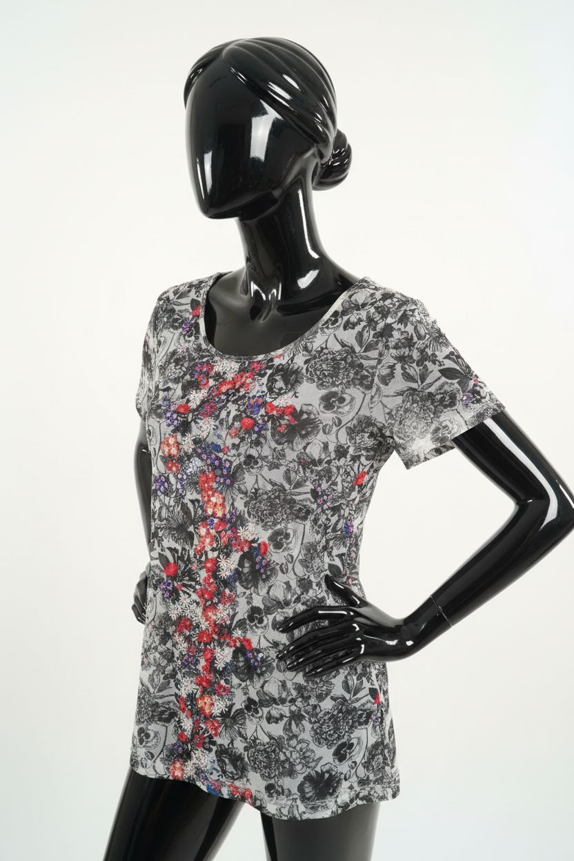 a glossy black plastic mannequin with no facial features in Women’s next top go over T-shirt arching their back slightly for a dynamic pose, in a clean photo studio with seamless white backdrop and softbox lighting.