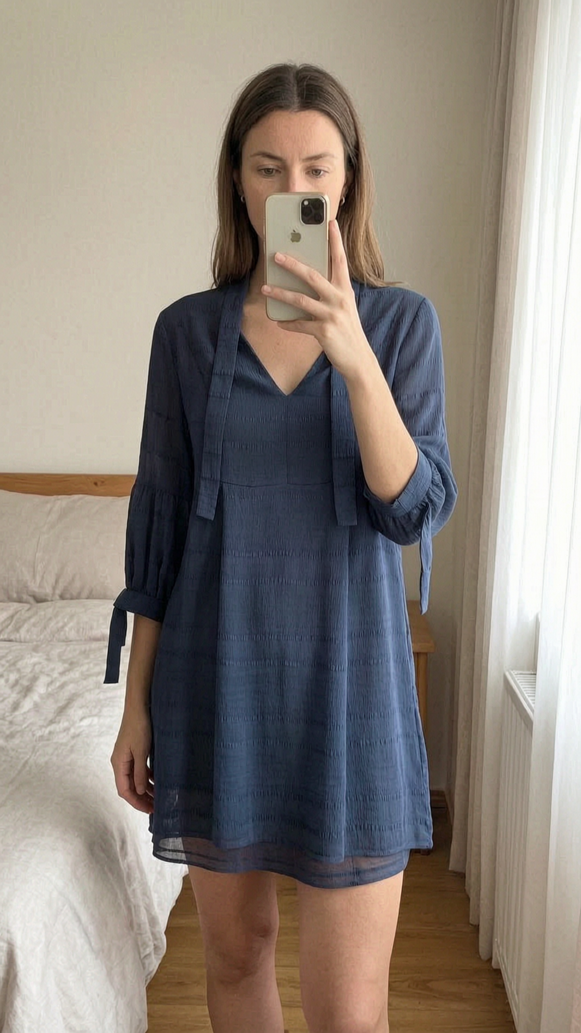 Whistles Mini Dress - Navy Blue - UK 8 standing straight facing the camera, in a softly lit bedroom setting, with gentle natural light filtering through a window.