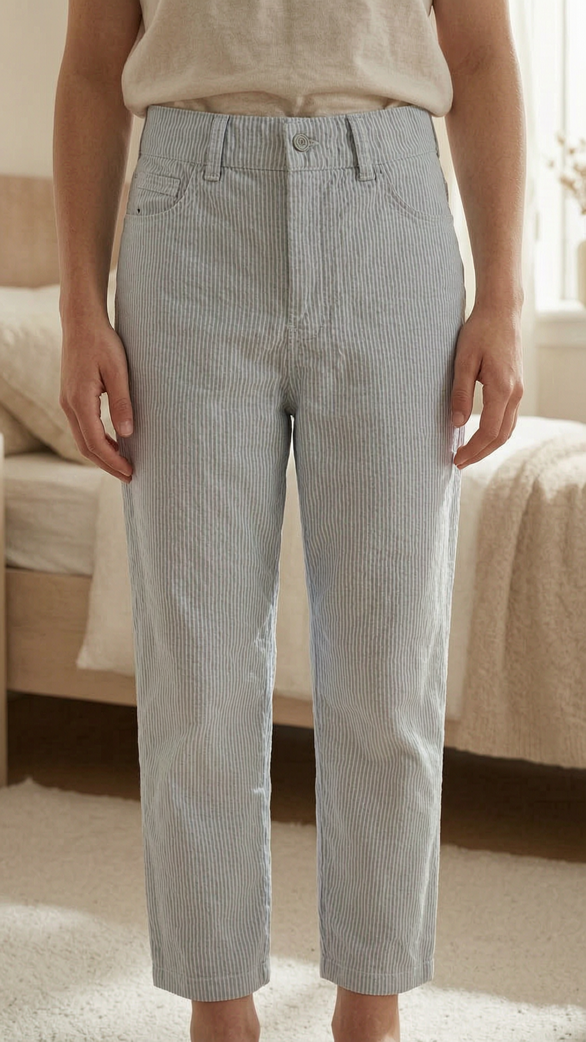 Summer pants Petit Bateau size 86 debout, face à la caméra, dans une chambre à la lumière douce, avec une lumière naturelle filtrant par la fenêtre.