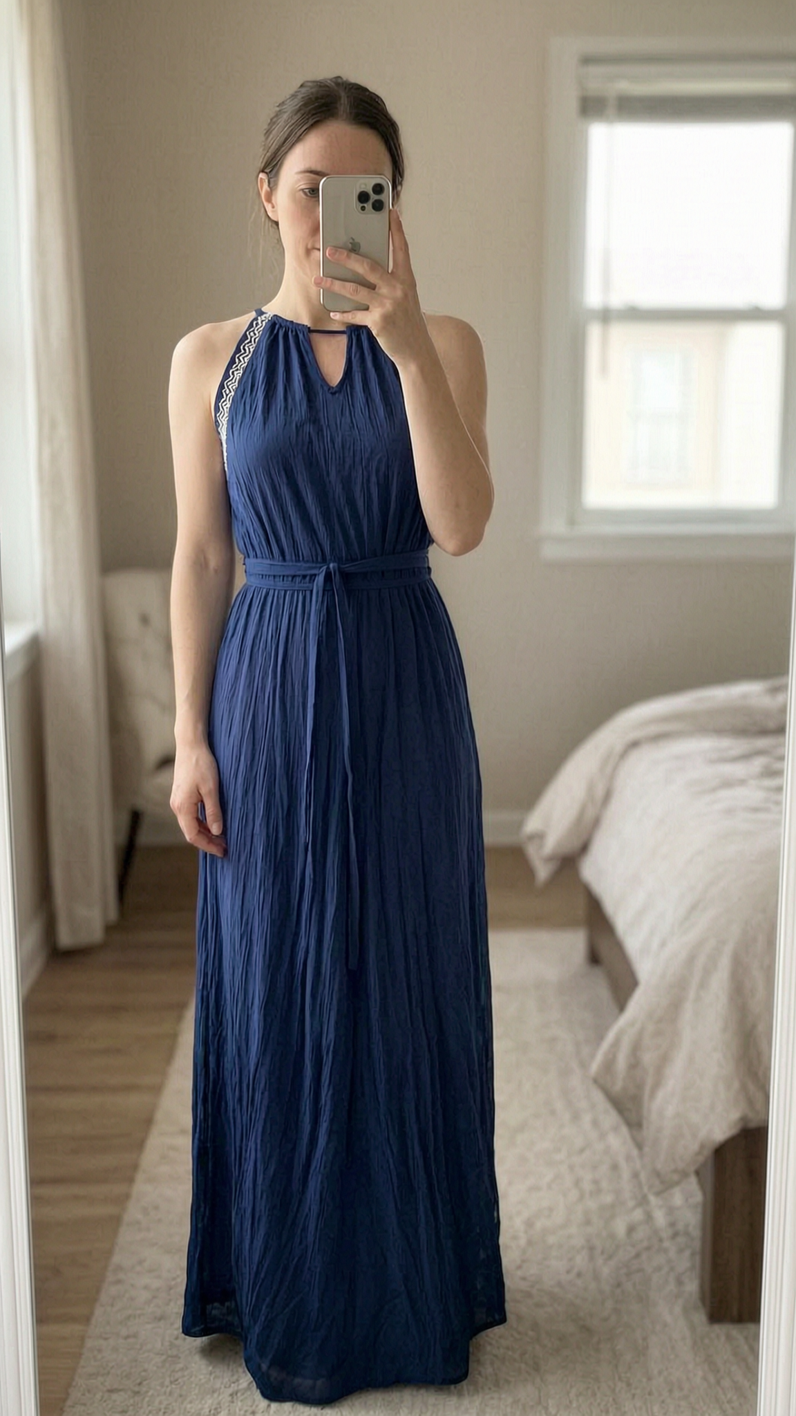 Schönes Kleid aufrecht stehend, der Kamera zugewandt, in einem sanft beleuchteten Schlafzimmer, mit natürlichem Licht, das durch ein Fenster fällt.