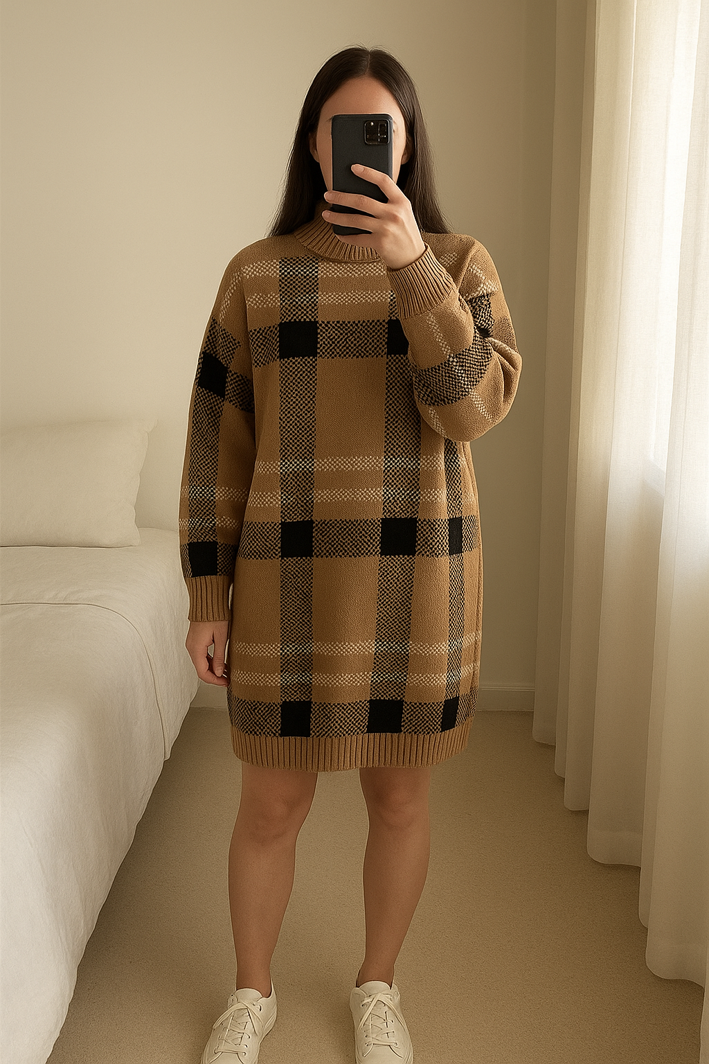 Robe pull debout, face à la caméra, dans une chambre à la lumière douce, avec une lumière naturelle filtrant par la fenêtre.