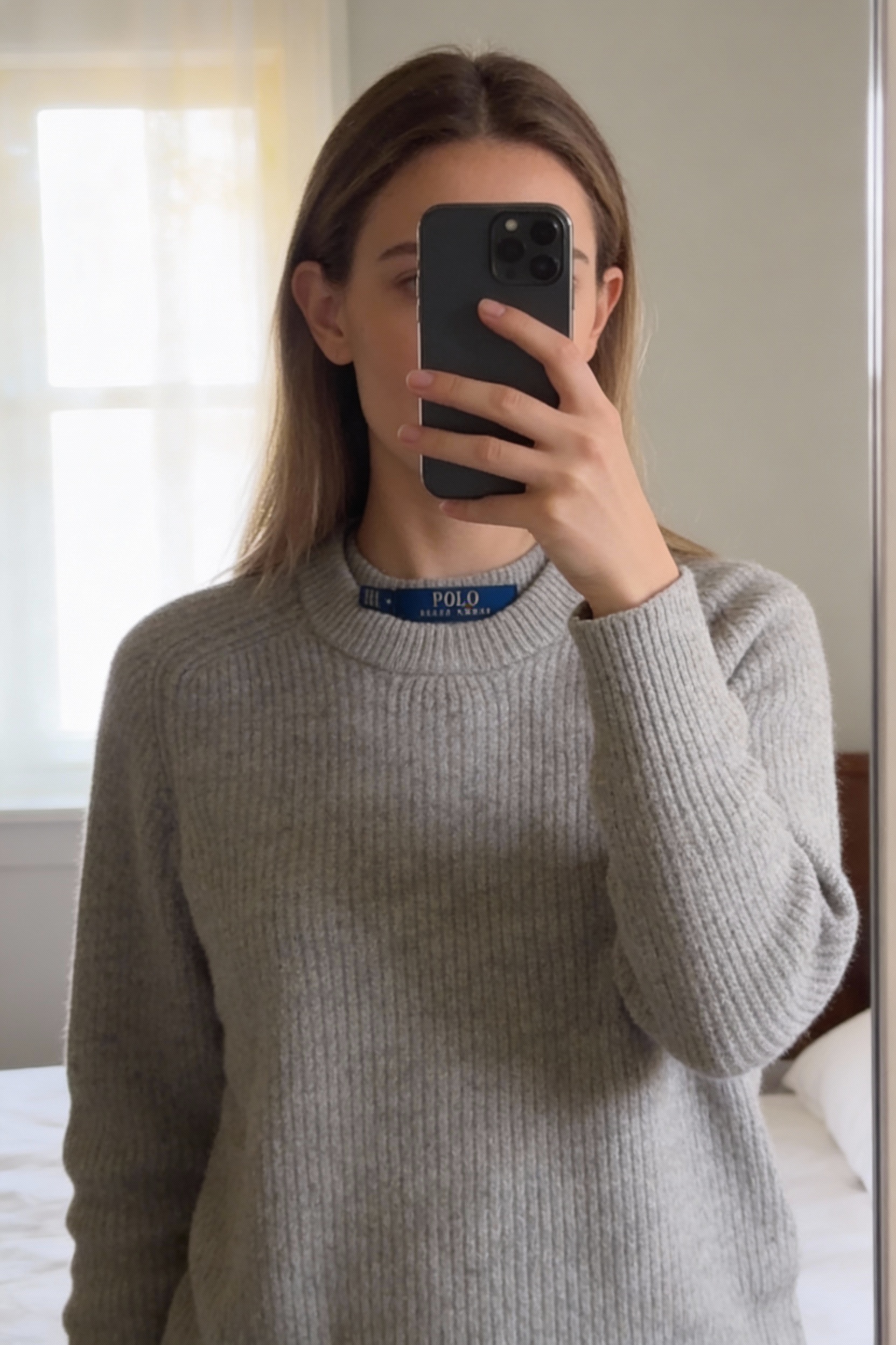 Pull tunique Ralph lauren femme Taille M 38 crème laine mérinos cachemire debout, face à la caméra, dans une chambre à la lumière douce, avec une lumière naturelle filtrant par la fenêtre.