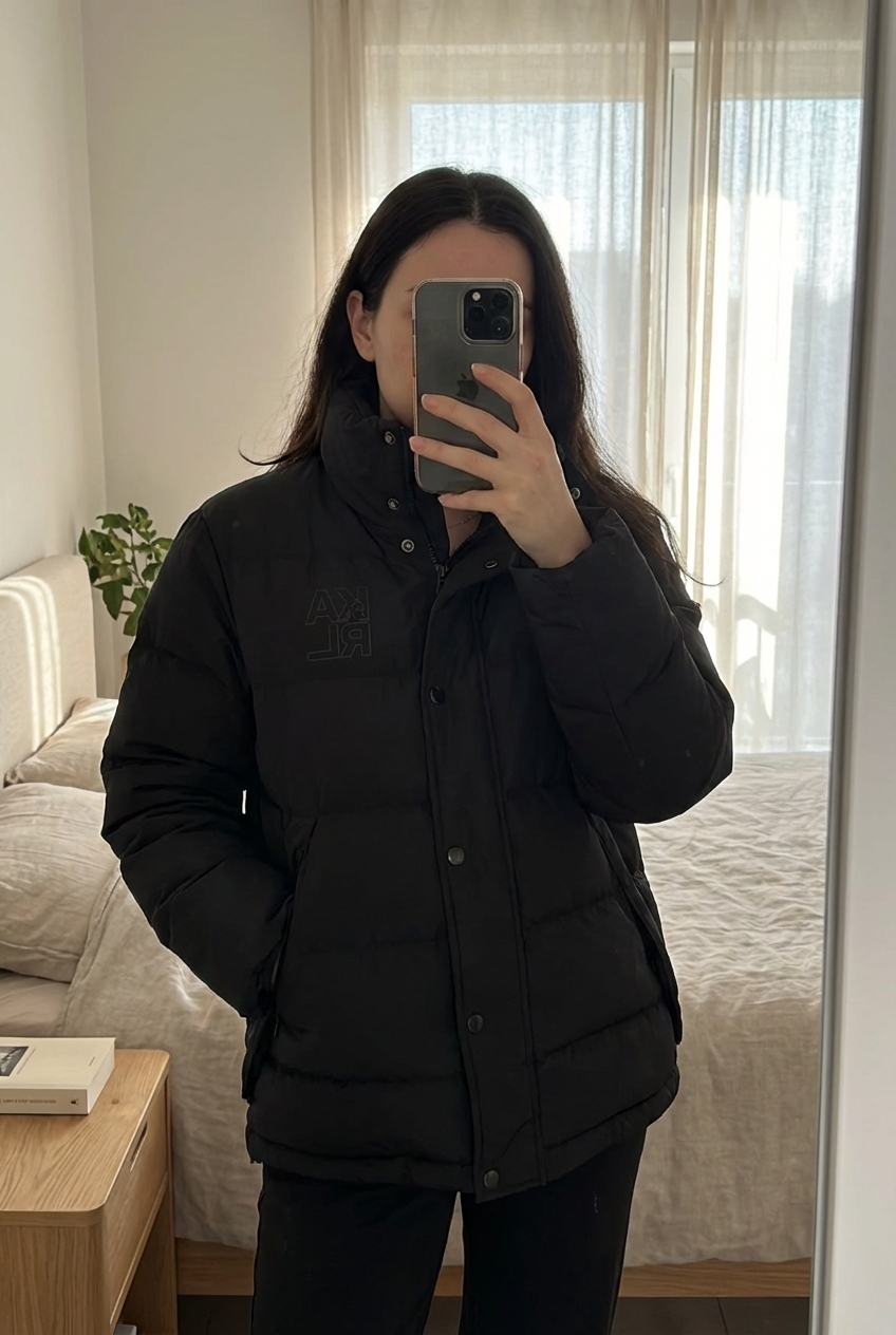 Karl Lagerfeld doudoune homme S hiver nylon debout, face à la caméra, dans une chambre à la lumière douce, avec une lumière naturelle filtrant par la fenêtre.