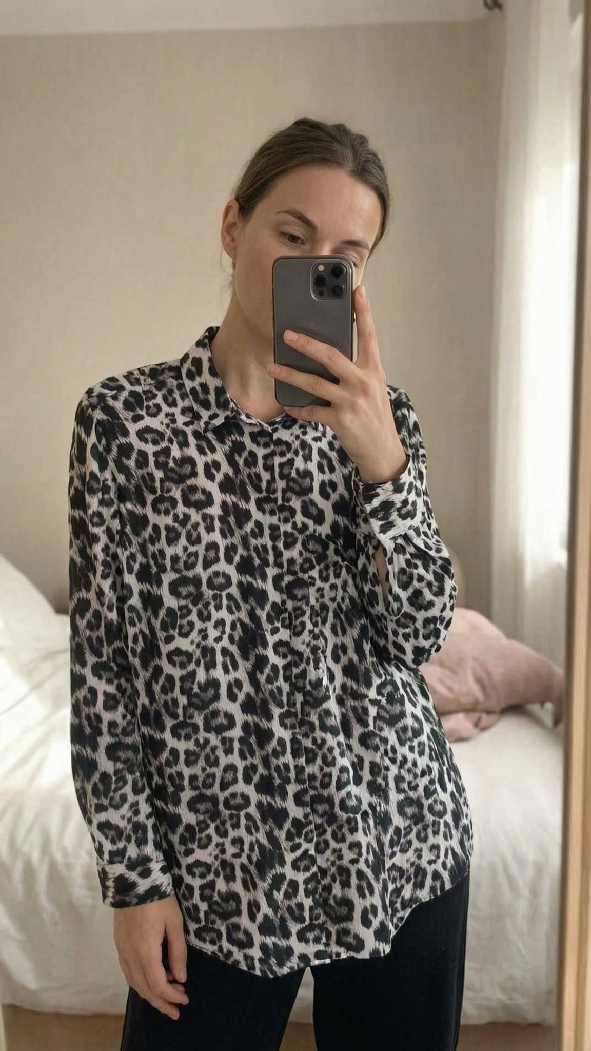 Zara black and white animal print lose fit blouse - size 14 standing straight facing the camera, in a softly lit bedroom setting, with gentle natural light filtering through a window.
