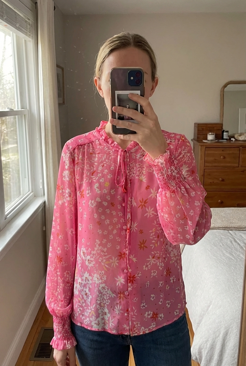 A person in Never Fully Dressed on trend summer staple floaty floral print blouse size medium fits 10-12 standing straight facing the camera, in a softly lit bedroom setting, with gentle natural light filtering through a window.