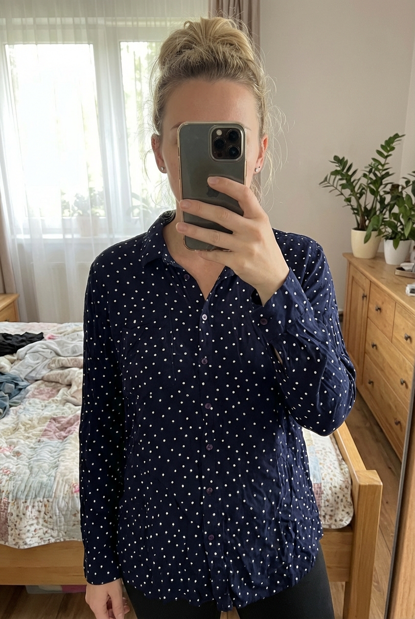 Chemisier inextenso 44 debout, face à la caméra, dans une chambre à la lumière douce, avec une lumière naturelle filtrant par la fenêtre.