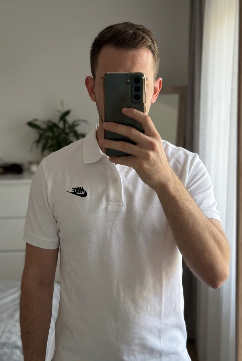 Lot de 2 polos nike, blanc L et noir M, bon état debout, face à la caméra, dans une chambre à la lumière douce, avec une lumière naturelle filtrant par la fenêtre.