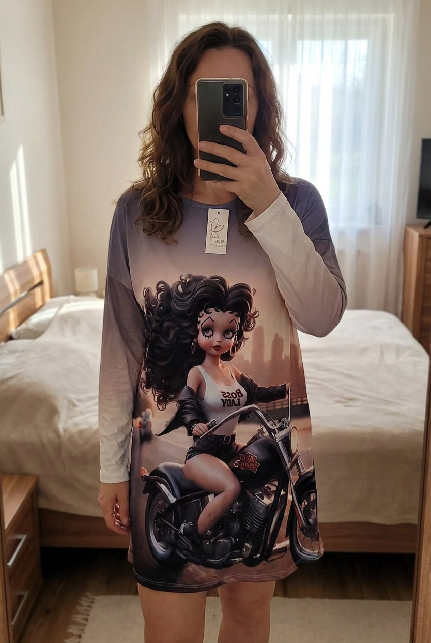 Robe betty baba grande taille debout, face à la caméra, dans une chambre à la lumière douce, avec une lumière naturelle filtrant par la fenêtre.