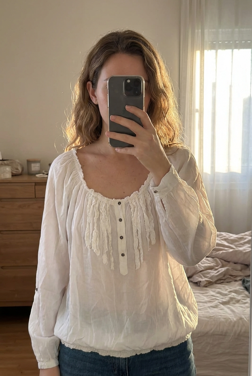 Haut Patrice breal debout, face à la caméra, dans une chambre à la lumière douce, avec une lumière naturelle filtrant par la fenêtre.