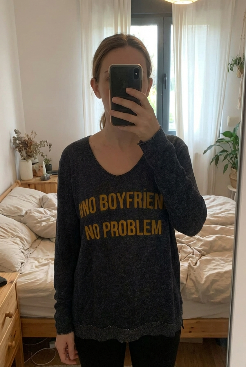 Haut manche longue bleu marine debout, face à la caméra, dans une chambre à la lumière douce, avec une lumière naturelle filtrant par la fenêtre.