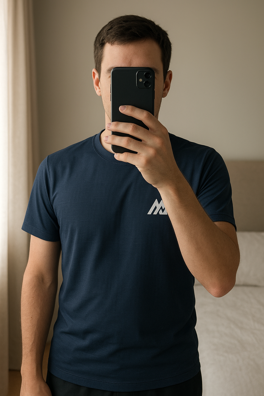 Montirex Men’s T’Shirt standing straight facing the camera, in a softly lit bedroom setting, with gentle natural light filtering through a window.