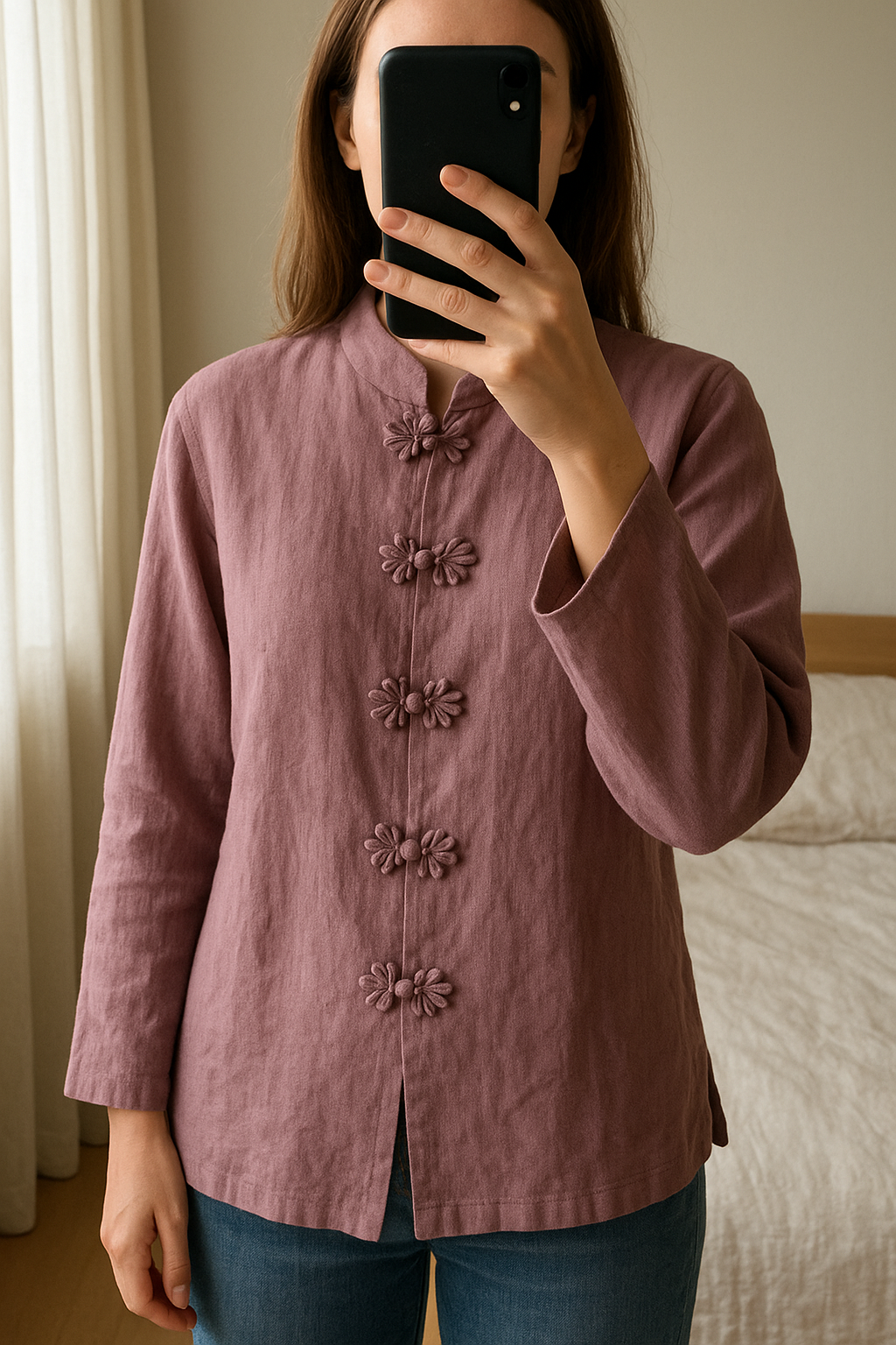 Tunique manches longues en lin debout, face à la caméra, dans une chambre à la lumière douce, avec une lumière naturelle filtrant par la fenêtre.