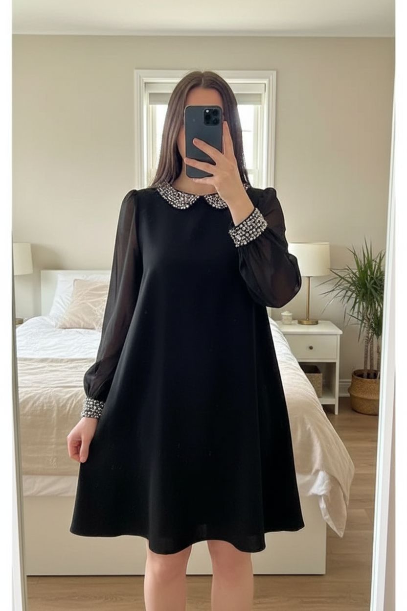Warehouse black sheer swing dress UK10 chiffon sleeve retro party beaded sparkly Wednesday Adams standing straight facing the camera, in a softly lit bedroom setting, with gentle natural light filtering through a window.