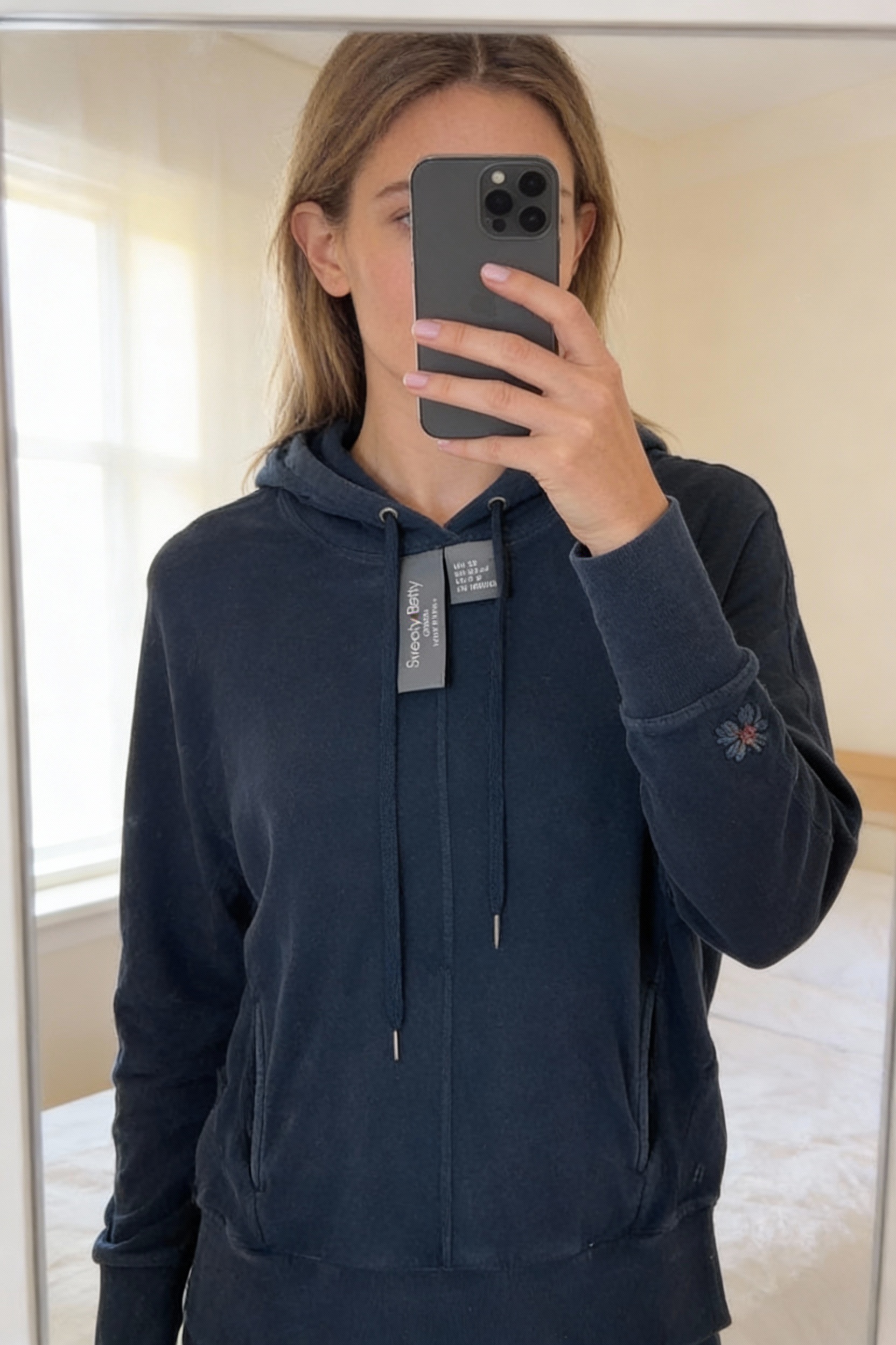 Sweaty Betty Liberate Luxe Fleece Navy Oversized Hoodie - XS - Casual Gym standing straight facing the camera, in a softly lit bedroom setting, with gentle natural light filtering through a window.