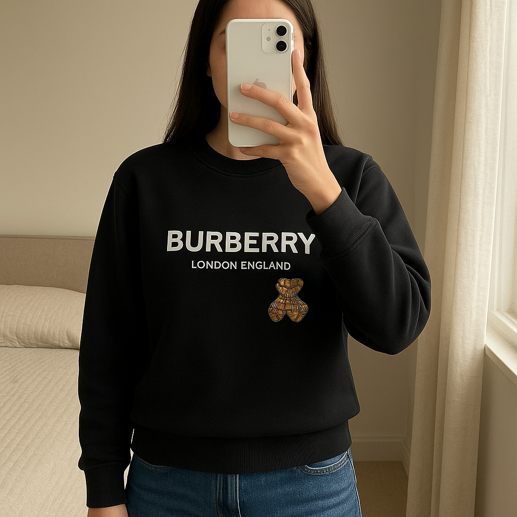 Teddy Bear Logo Sweatshirt Black – Size Small | Designer Crewneck Jumper standing straight facing the camera, in a softly lit bedroom setting, with gentle natural light filtering through a window.
