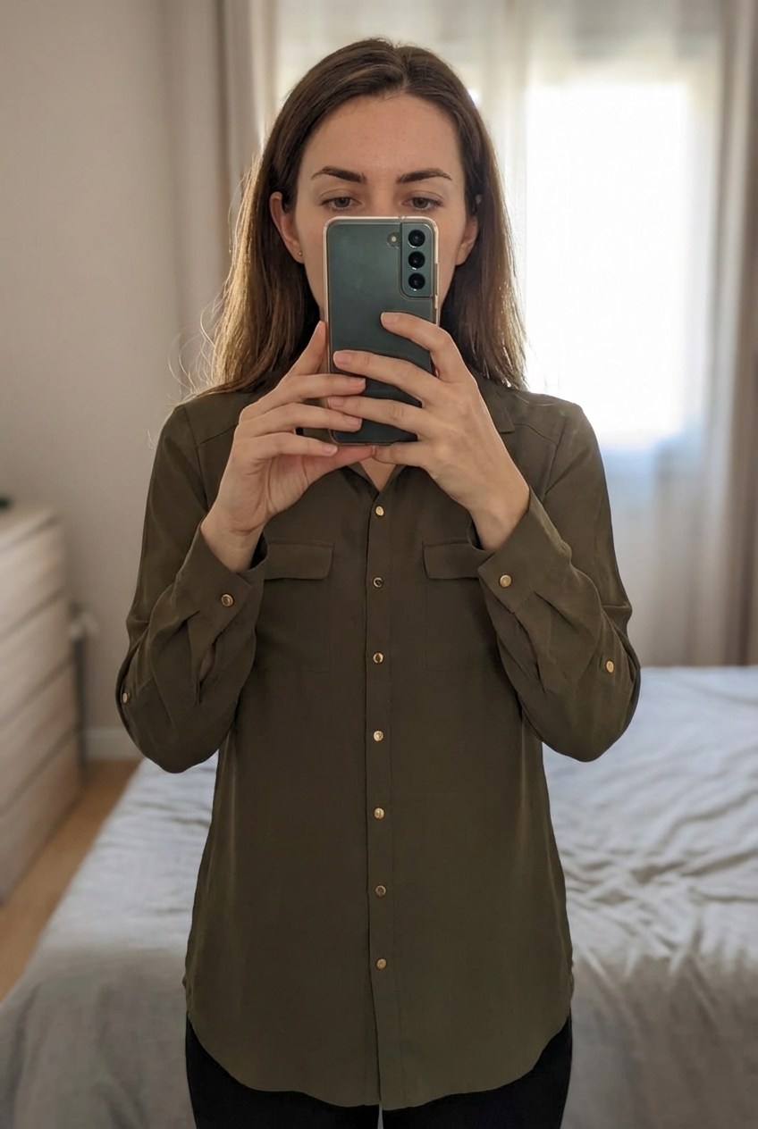 Chemise femme debout, face à la caméra, dans une chambre à la lumière douce, avec une lumière naturelle filtrant par la fenêtre.