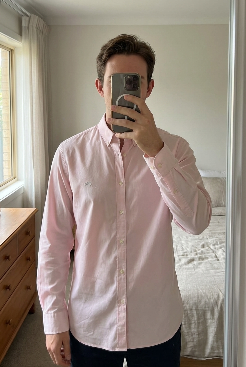 Chemise Lacoste - Rose - Taille 43 - Slim Fit debout, face à la caméra, dans une chambre à la lumière douce, avec une lumière naturelle filtrant par la fenêtre.