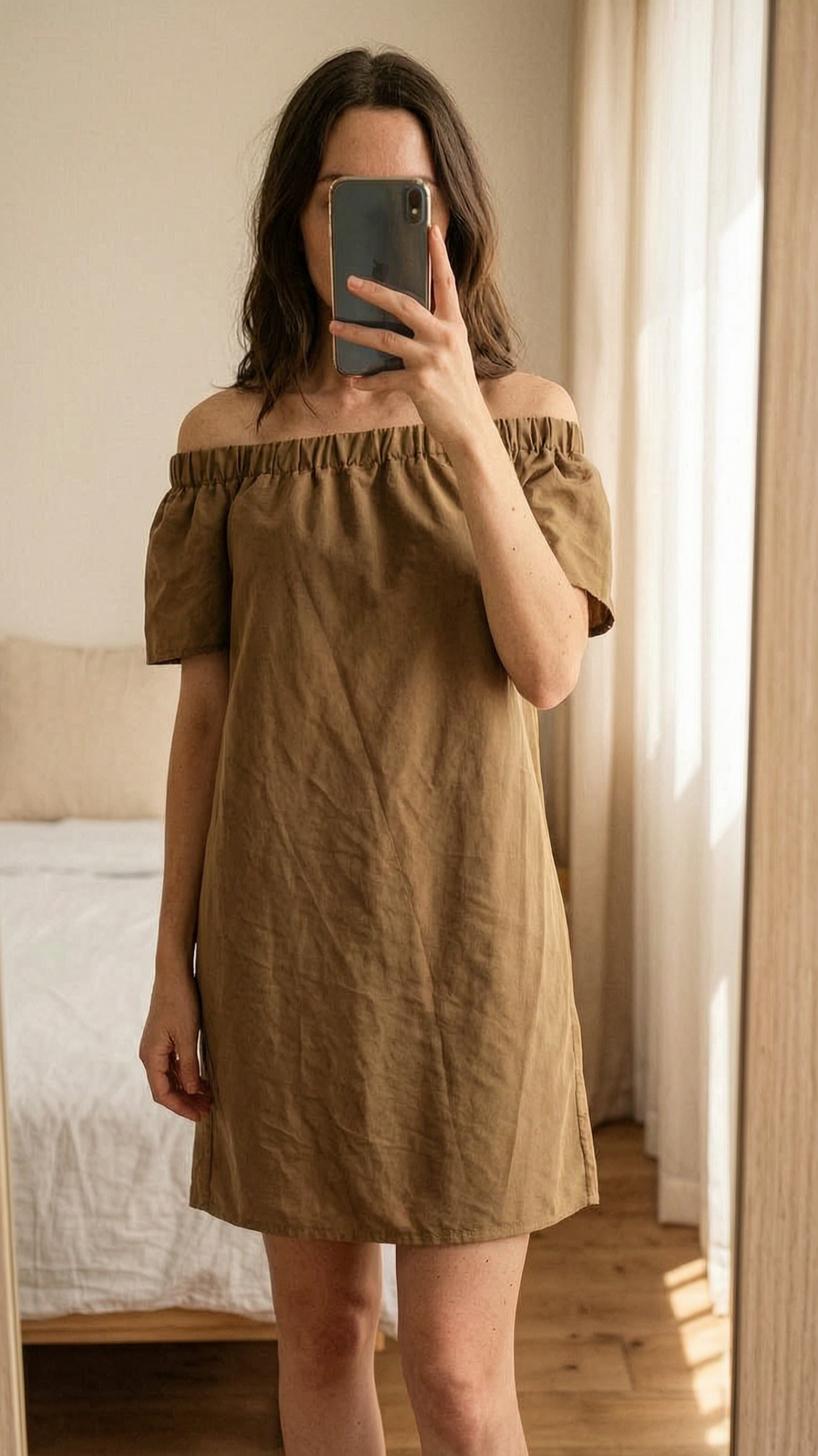 H&M Kleid braun Gr. 36 aufrecht stehend, der Kamera zugewandt, in einem sanft beleuchteten Schlafzimmer, mit natürlichem Licht, das durch ein Fenster fällt.
