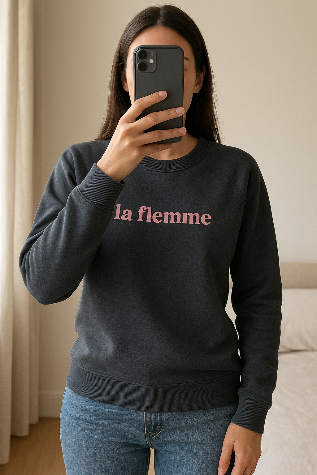 Sweat de sport, "la flemme" Kiabi, gris foncé et rose debout, face à la caméra, dans une chambre à la lumière douce, avec une lumière naturelle filtrant par la fenêtre.