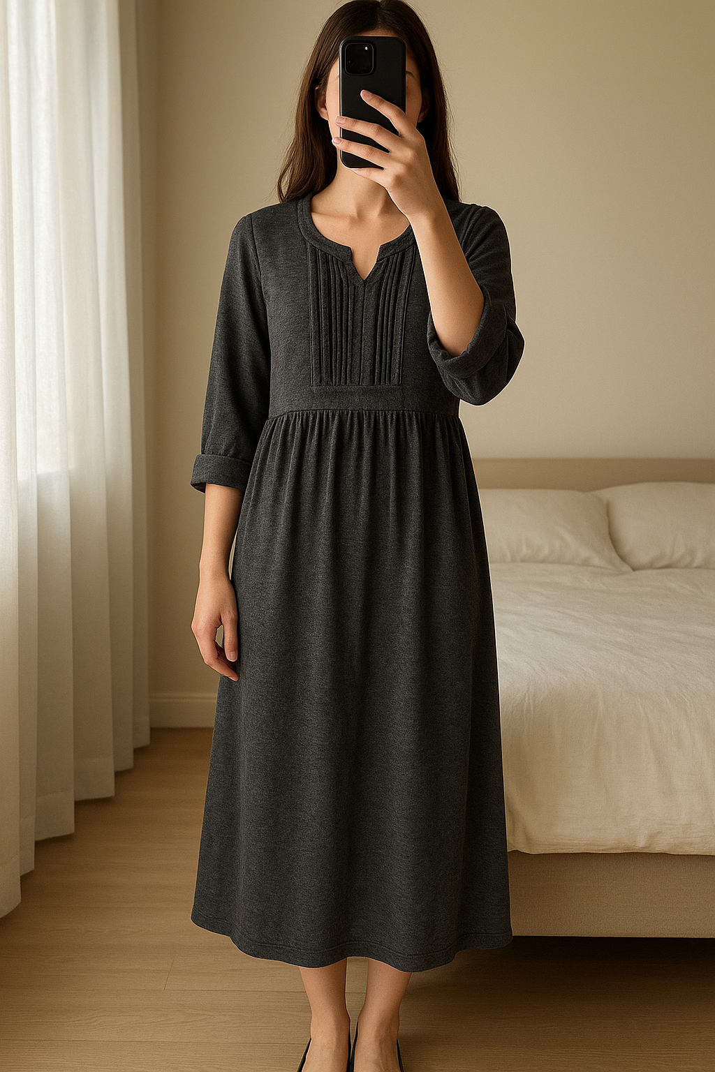 Wollen jurk Essentiel - als nieuw - maat 36 debout, face à la caméra, dans une chambre à la lumière douce, avec une lumière naturelle filtrant par la fenêtre.