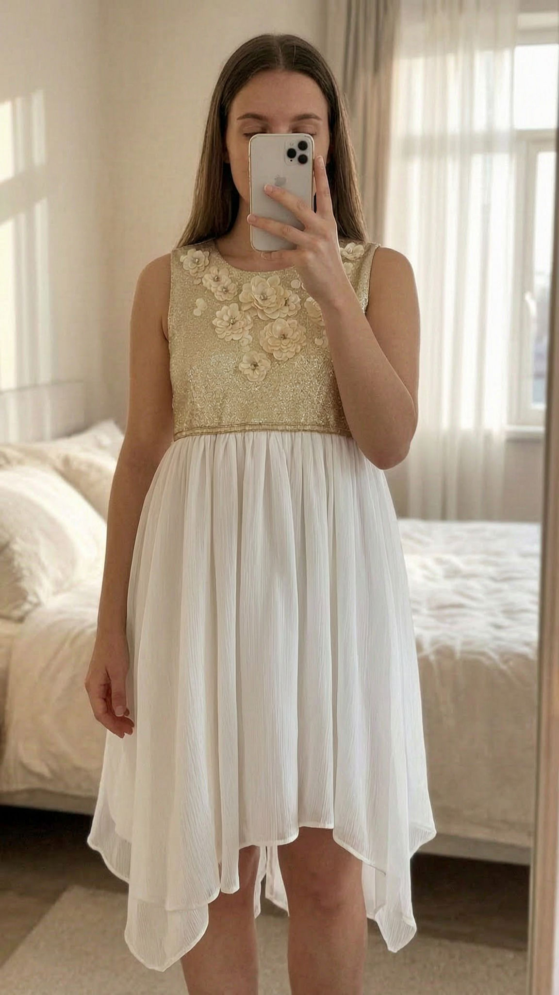 Monsoon white and gold dress for girls 4 years old standing straight facing the camera, in a softly lit bedroom setting, with gentle natural light filtering through a window.
