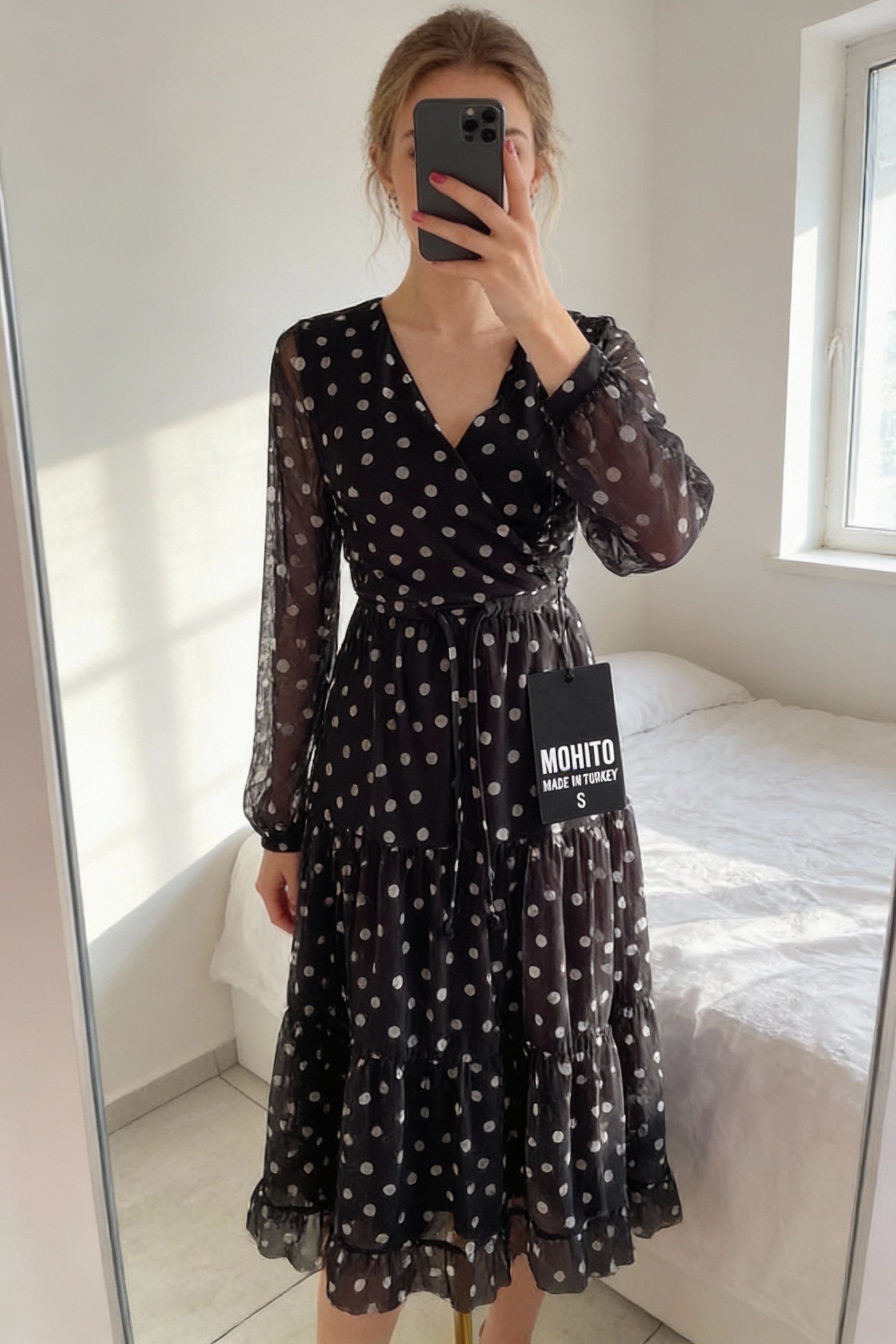 Krásne Mohito šaty standing straight facing the camera, in a softly lit bedroom setting, with gentle natural light filtering through a window.