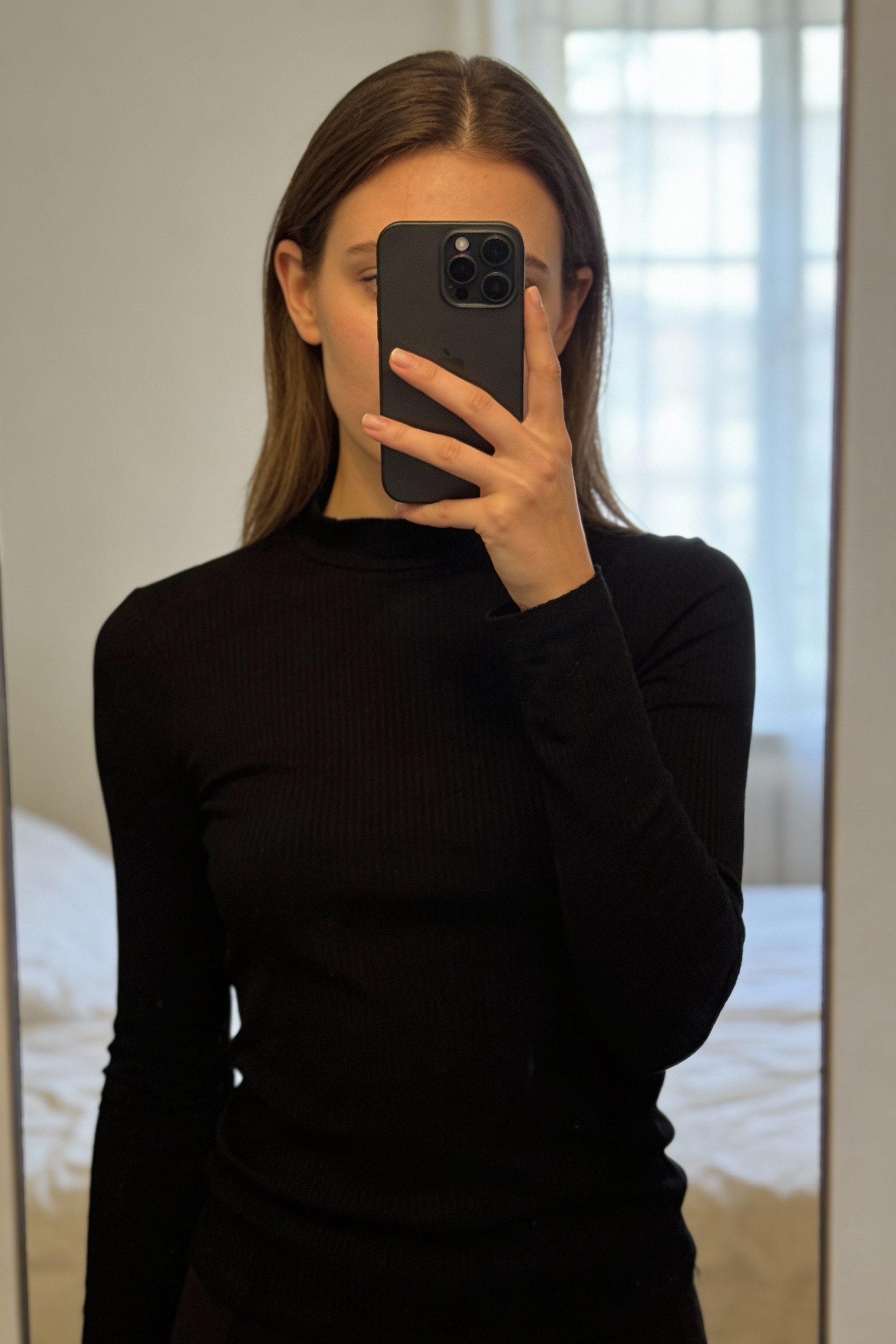 ZARA black long-sleeve blouse. standing straight facing the camera, in a softly lit bedroom setting, with gentle natural light filtering through a window.