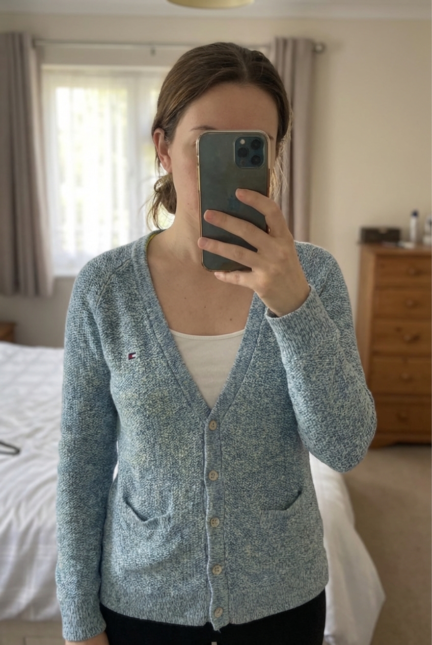 Vintage Tommy Hilfiger Blue Marl Knit Cardigan Button Front Size S/M standing straight facing the camera, in a softly lit bedroom setting, with gentle natural light filtering through a window.