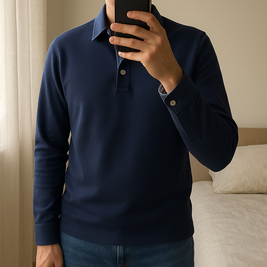 Polo Manica Lunga in Cotone Finezza 10 - Blu Notte in piedi, rivolto verso la fotocamera, in una camera da letto con luce soffusa e luce naturale che filtra dalla finestra.
