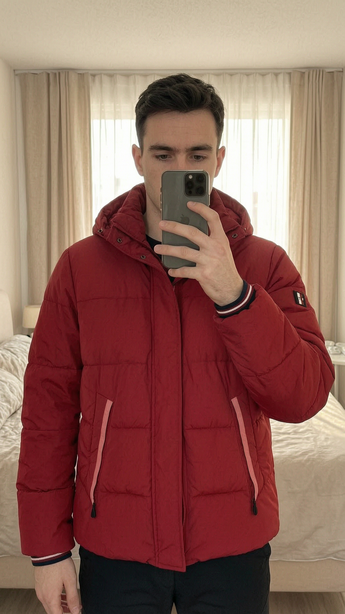 Tommy Hilfiger Red Hooded Puffer Jacket Water Repellent – Size M – Perfect Spring Layer standing straight facing the camera, in a softly lit bedroom setting, with gentle natural light filtering through a window.