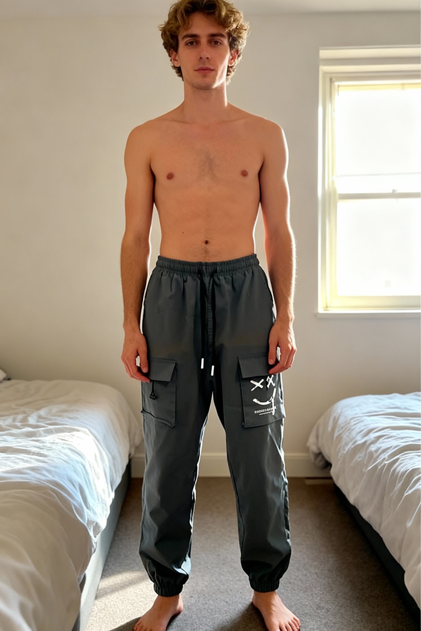 Cargo debout, face à la caméra, dans une chambre à la lumière douce, avec une lumière naturelle filtrant par la fenêtre.