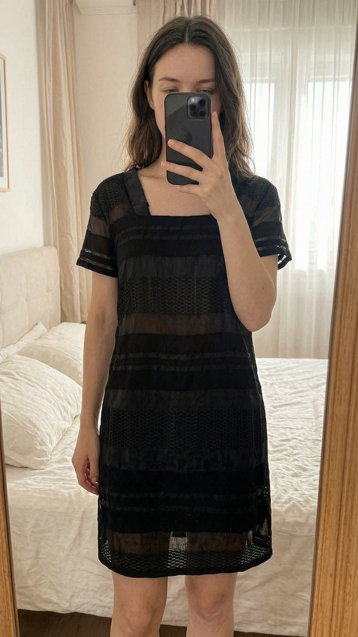 Robe présent COP copine debout, face à la caméra, dans une chambre à la lumière douce, avec une lumière naturelle filtrant par la fenêtre.