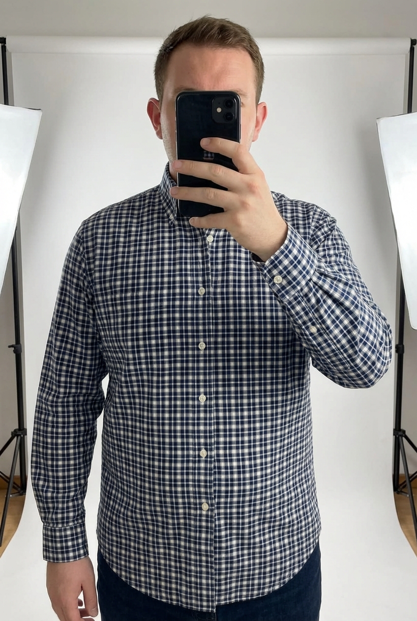 Une personne en Chemise TM Lewin à carreaux bleu marine et blanc 100% coton - Taille M debout, face à la caméra, avec une silhouette légèrement plus ronde, dans un studio photo épuré avec fond blanc et éclairage doux.