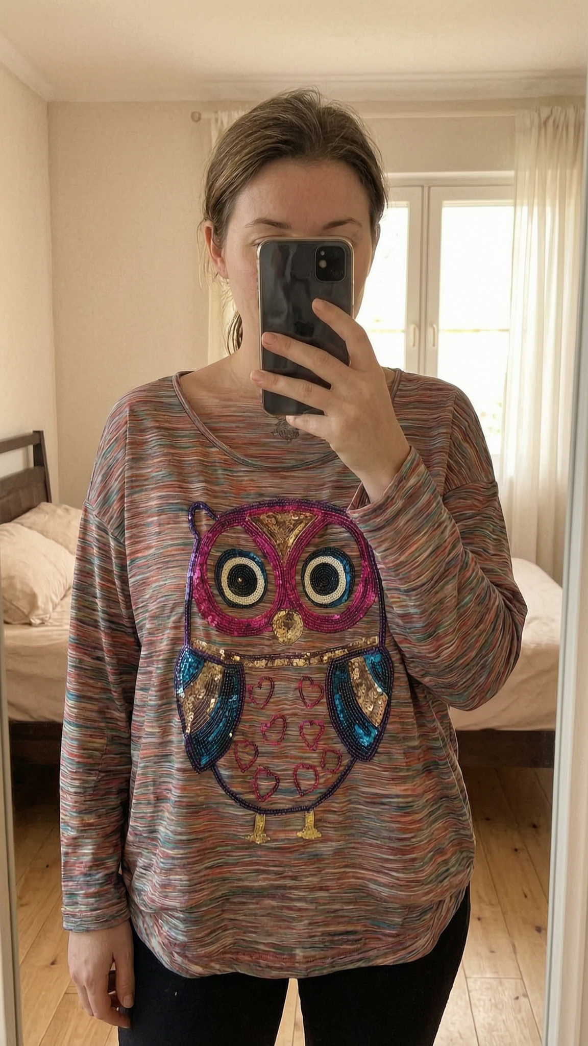 Tee-shirt debout, face à la caméra, dans une chambre à la lumière douce, avec une lumière naturelle filtrant par la fenêtre.