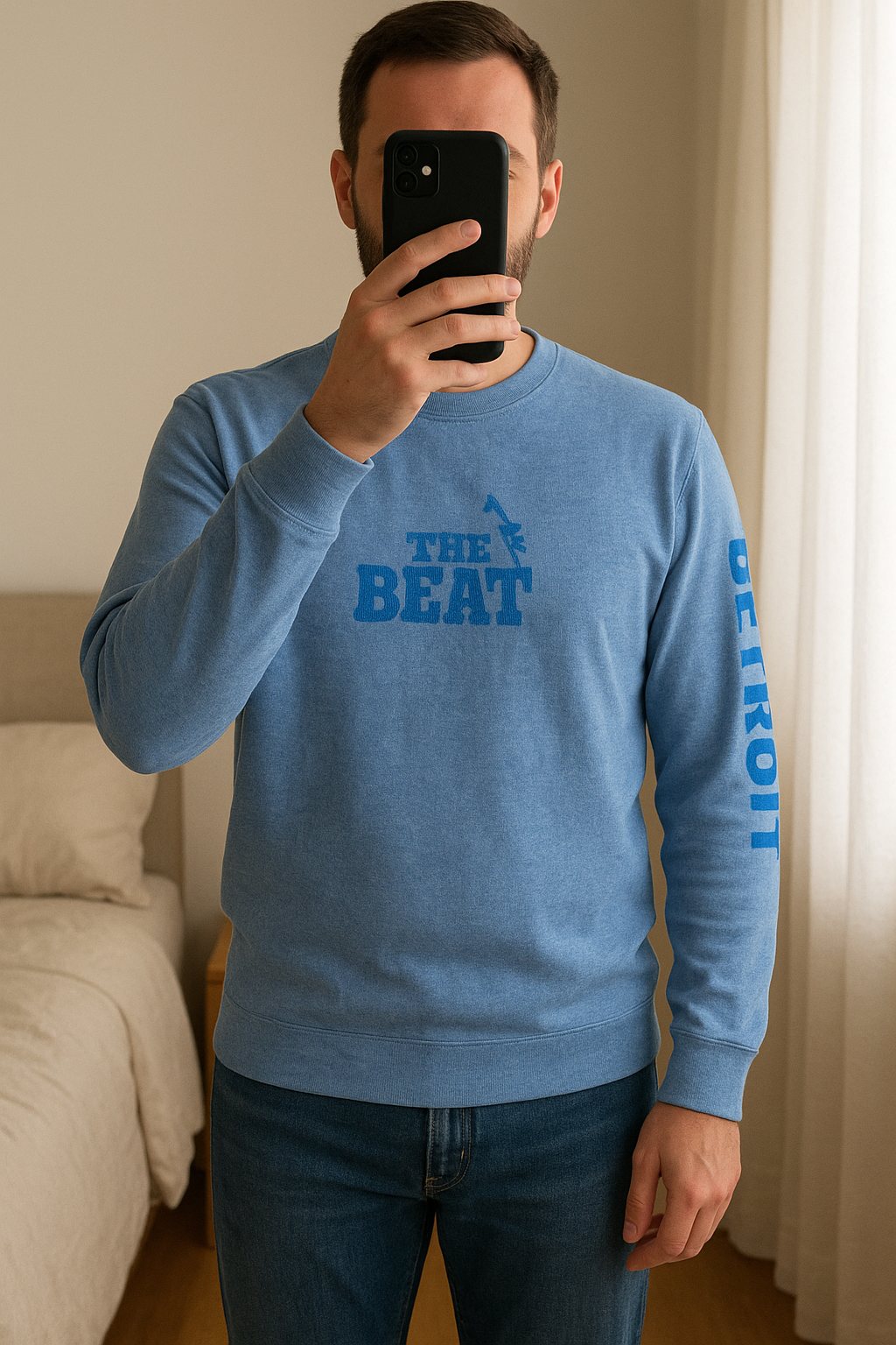 Felpa Abercrombie&Fitch in piedi, rivolto verso la fotocamera, in una camera da letto con luce soffusa e luce naturale che filtra dalla finestra.