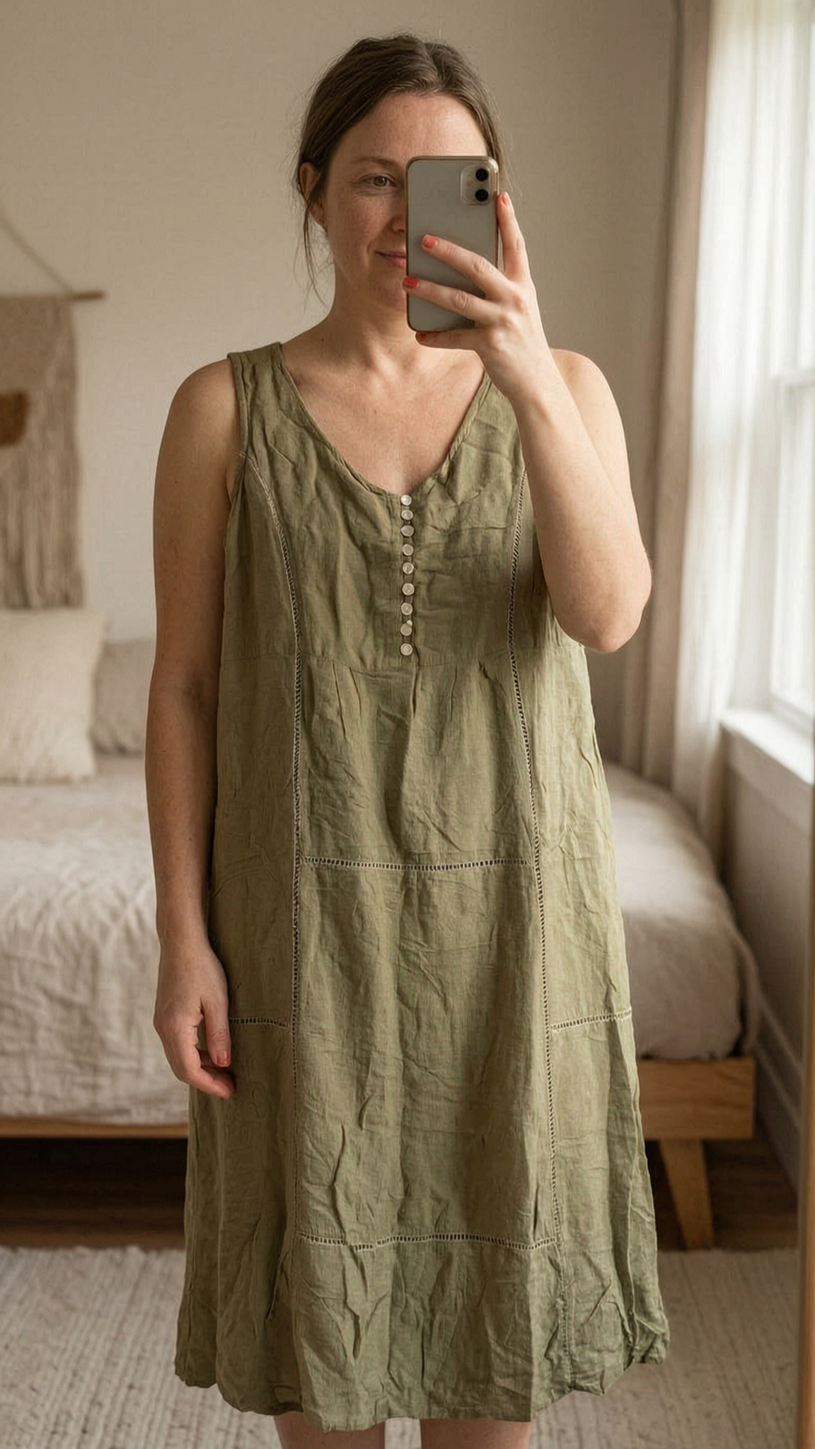 Robe en lin été femme M - abito in lino donna M in piedi, rivolto verso la fotocamera, in una camera da letto con luce soffusa e luce naturale che filtra dalla finestra.