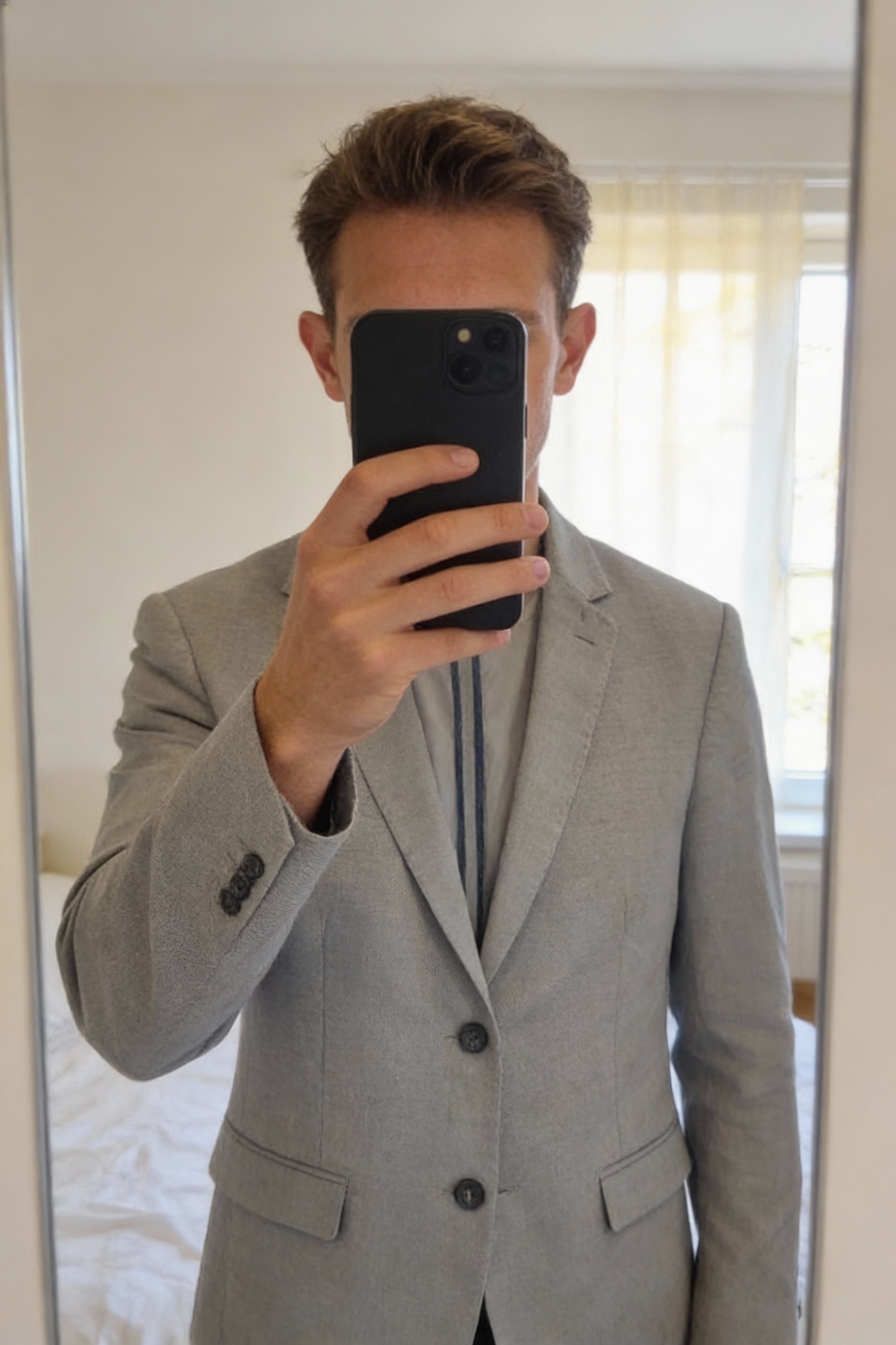 Veste costume légère Jules homme TAille S debout, face à la caméra, dans une chambre à la lumière douce, avec une lumière naturelle filtrant par la fenêtre.