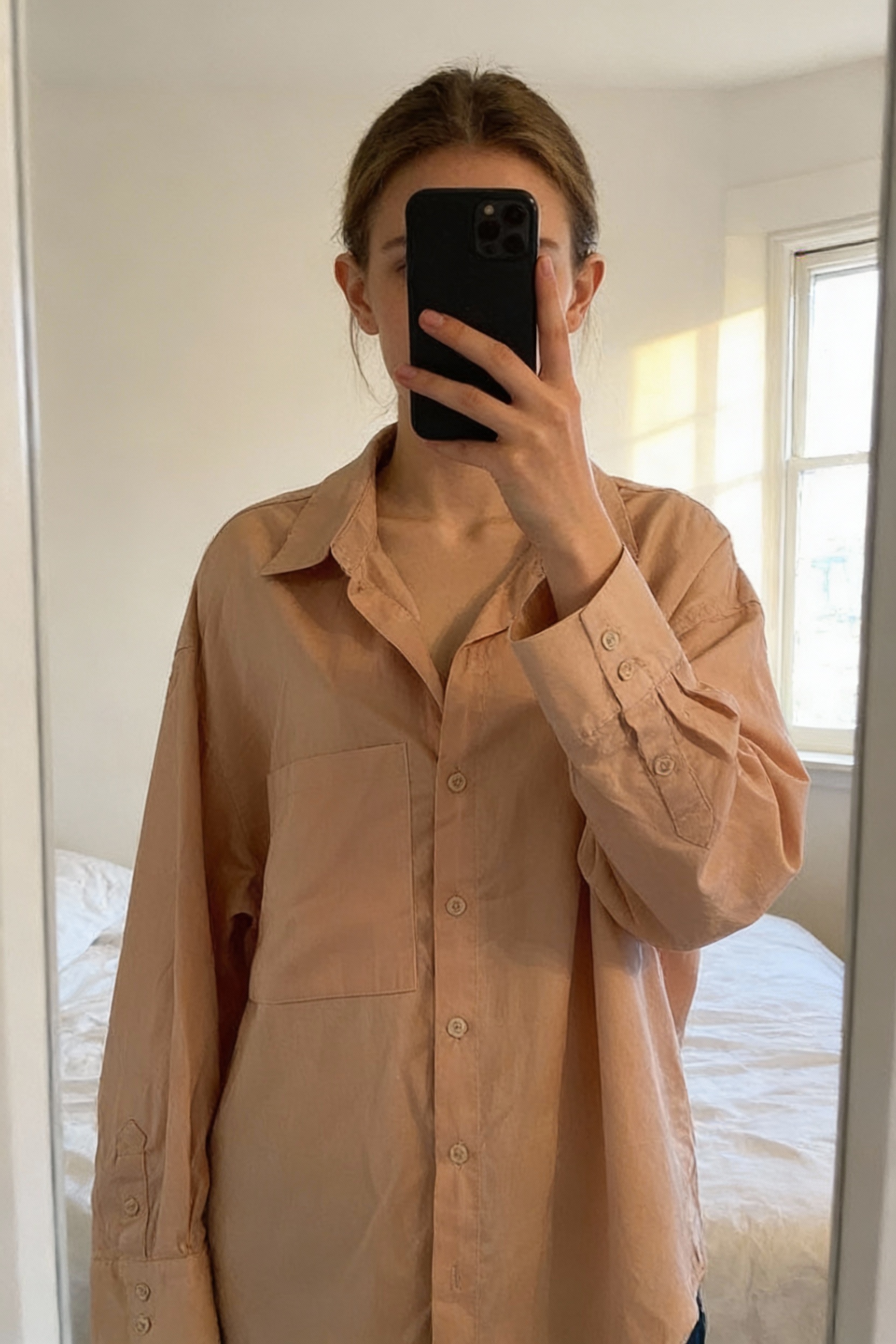 H&M Divided 100% cotton poplin long sleeved shirt size medium 12-14 standing straight facing the camera, in a softly lit bedroom setting, with gentle natural light filtering through a window.
