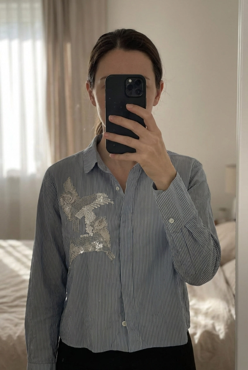 Chemise à rayures debout, face à la caméra, dans une chambre à la lumière douce, avec une lumière naturelle filtrant par la fenêtre.