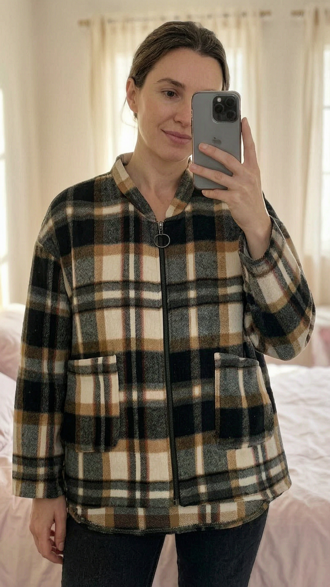 🤎 Veste à carreaux légère manches 3/4 debout, face à la caméra, dans une chambre à la lumière douce, avec une lumière naturelle filtrant par la fenêtre.
