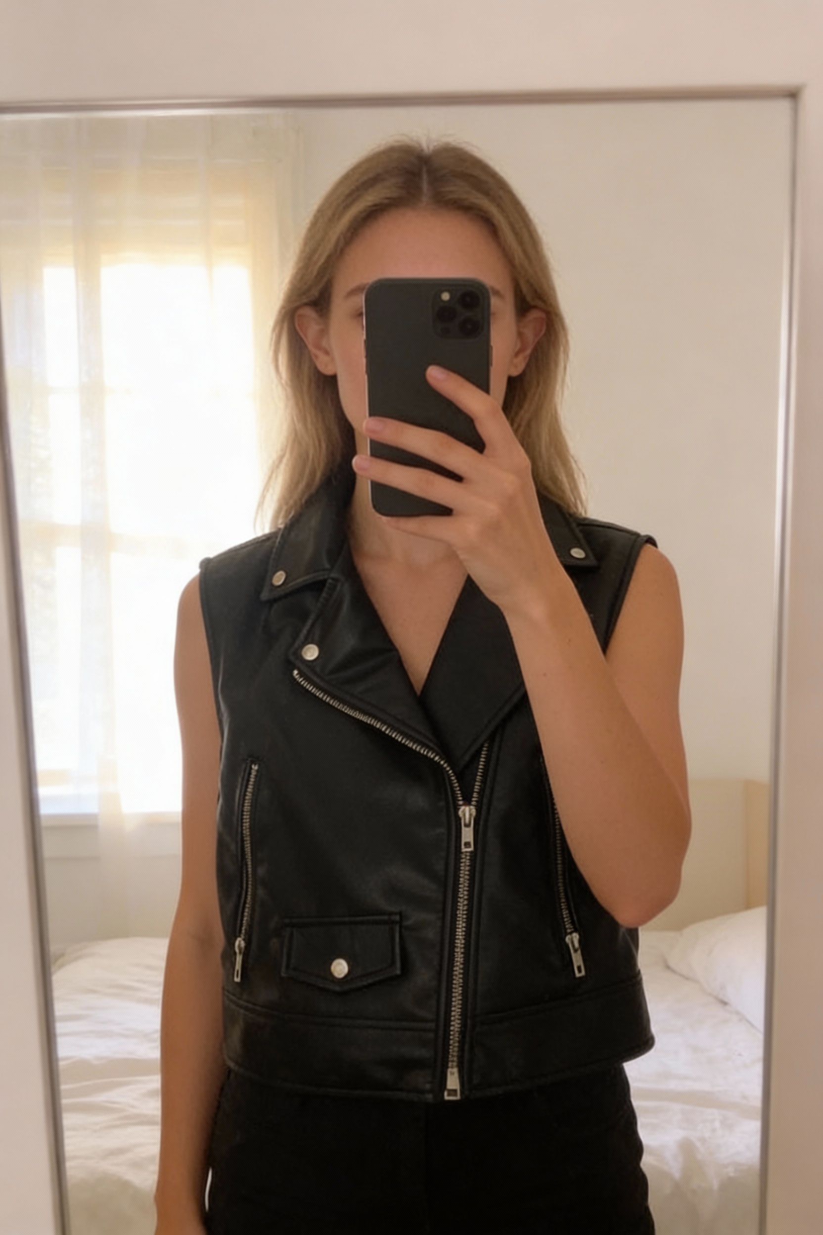 Veste zara debout, face à la caméra, dans une chambre à la lumière douce, avec une lumière naturelle filtrant par la fenêtre.