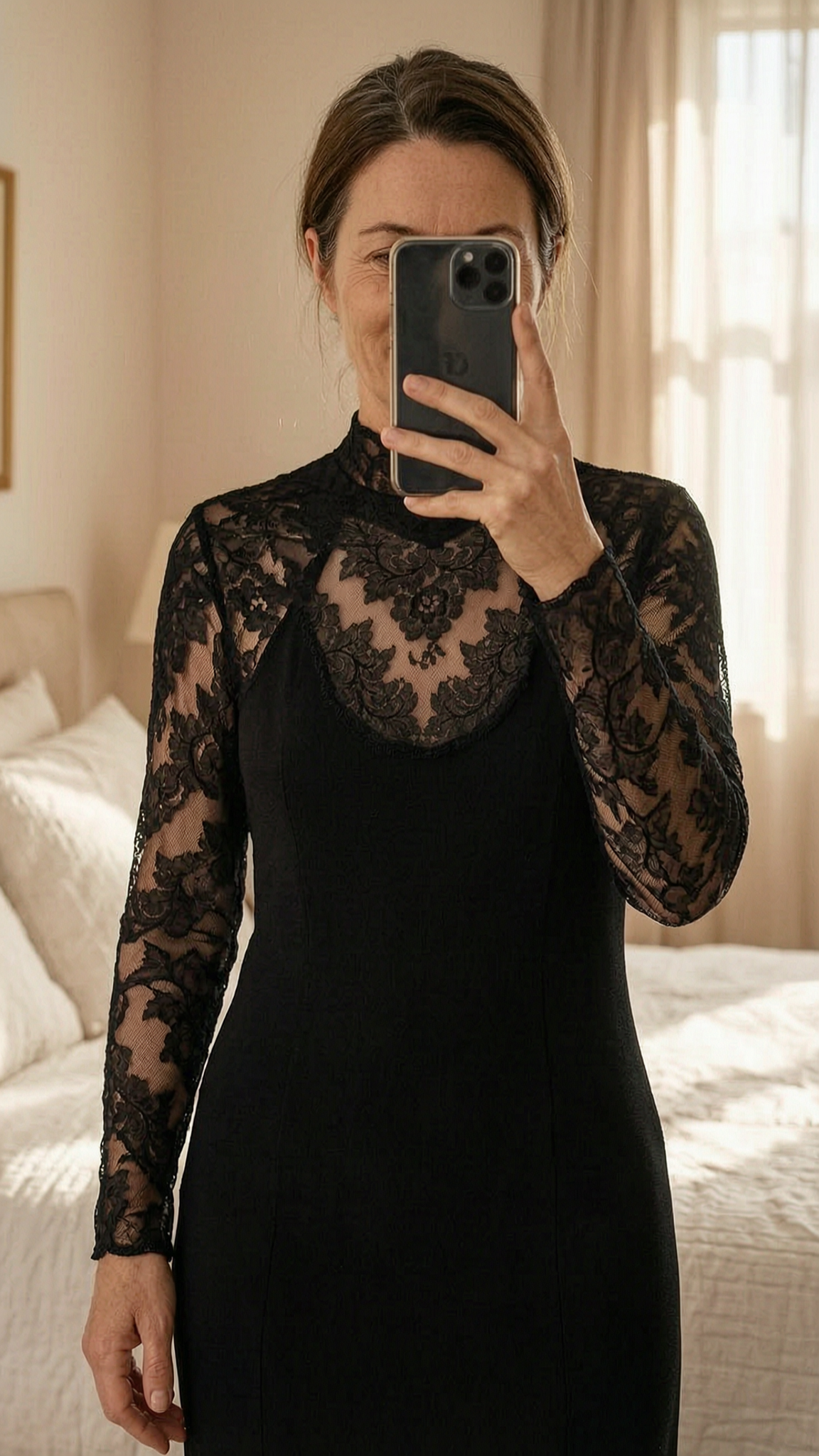 robe noire Jiki Monte Carlo Creations 40 debout, face à la caméra, dans une chambre à la lumière douce, avec une lumière naturelle filtrant par la fenêtre.