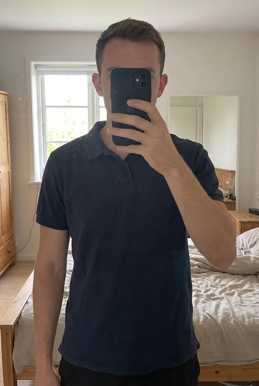 Polo homme union basics taille xl debout, face à la caméra, dans une chambre à la lumière douce, avec une lumière naturelle filtrant par la fenêtre.