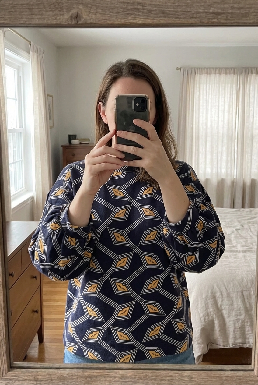 Pull court à manches 3/4 Ted Baker London motif géométriqueoriginal - Taille M debout, face à la caméra, dans une chambre à la lumière douce, avec une lumière naturelle filtrant par la fenêtre.