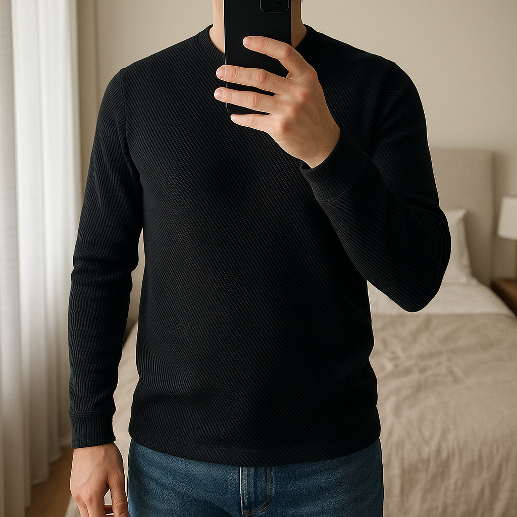 Pull Noir Zara Taille M Homme debout, face à la caméra, dans une chambre à la lumière douce, avec une lumière naturelle filtrant par la fenêtre.